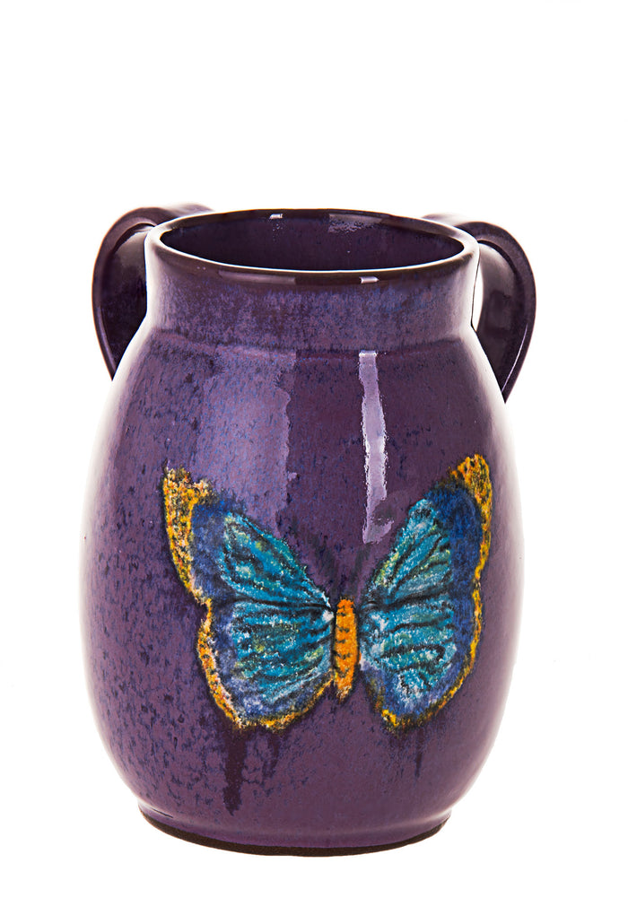 Eggplant purple stoneware wash cup with two handles and a blue and gold butterfly on the front
