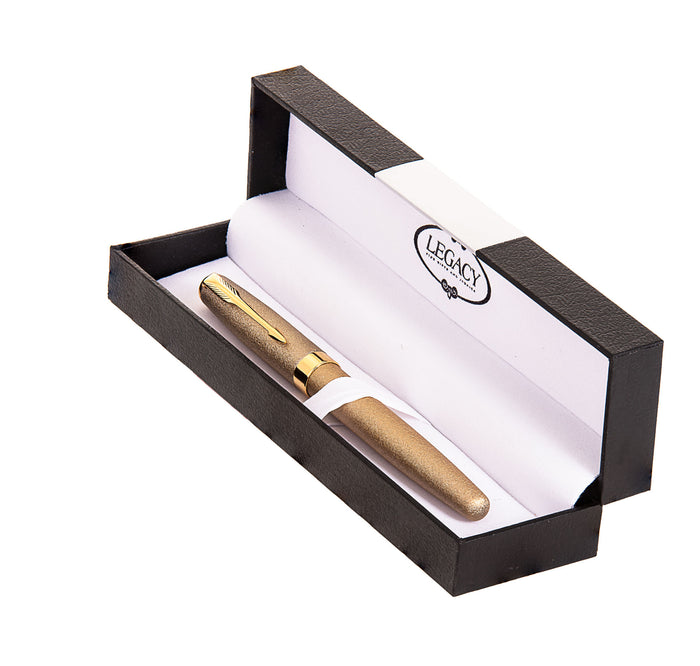 Gold-tone textured pen with gold clip resting in an open black box with Legacy-branded lining