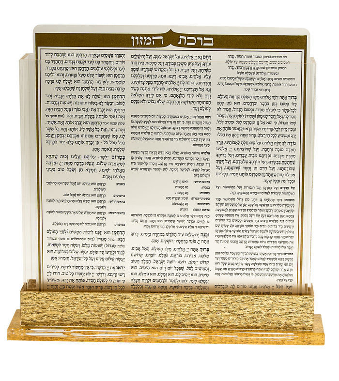 Clear Lucite bencher holder on a gold-tone base showing the Birkat Hamazon bencher cover