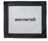 White vinyl challah cover with wide black border and Hebrew L'kavod Shabbat V'Yom Tov in black