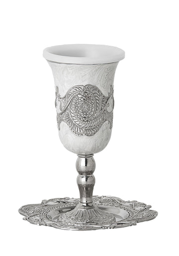 White enamel Kiddush cup with silver-tone filigree band on a stem, set on a scalloped filigree tray