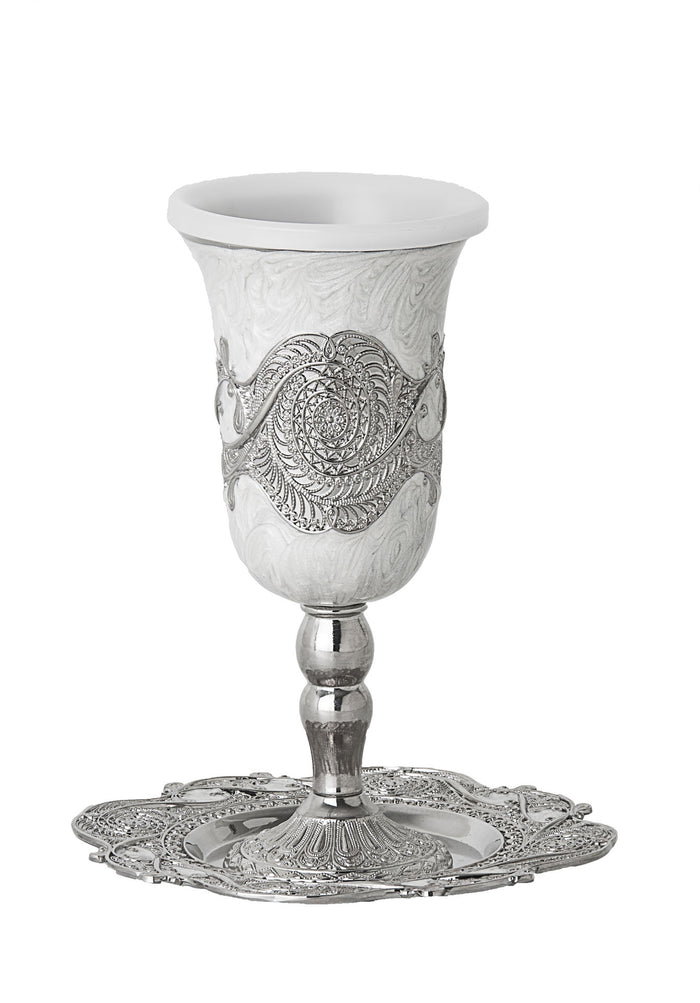White enamel Kiddush cup with silver-tone filigree band on a stem, set on a scalloped filigree tray