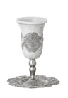 White enamel Kiddush cup with silver-tone filigree band on a stem, set on a scalloped filigree tray