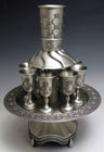 Pewter eight-cup wine fountain with lattice and rosette pattern goblets on a round rimmed tray