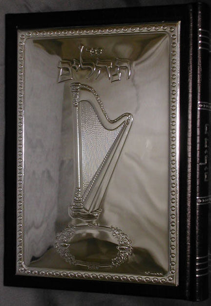 Leather-bound Tehillim with a sterling silver harp cover and Hebrew title, spine visible at right