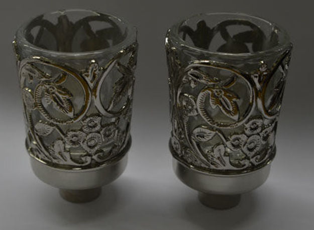 Two neronim with open silver-tone leaf and blossom scrollwork around clear cups on grey