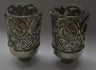 Two neronim with open silver-tone leaf and blossom scrollwork around clear cups on grey