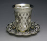 Small silver plated kiddush cup on a slender stem resting on its round saucer