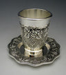 Silver plated Kiddush cup with raised grape clusters on a scalloped tray with a grapevine border