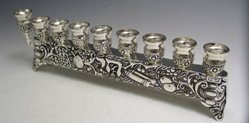 Low silver plated row menorah with nine cups, a raised end shamash and a relief-decorated base