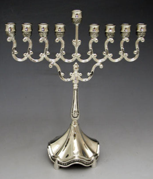 Compact silver plated menorah with looping scroll arms, raised center shamash and scalloped base
