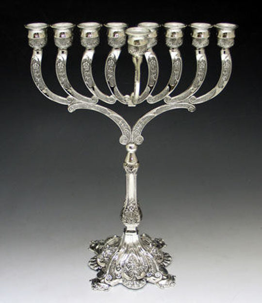 Silver plated menorah with engraved curved arms, a raised center shamash and an ornate footed base