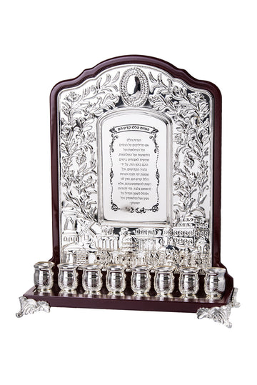 Wall style menorah with dark wood back, silver plated floral panel, Hebrew text and nine cups along the base
