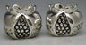 Two silver-tone pomegranate-shaped tea light holders with Jerusalem relief and open grid centers