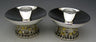 Two low candlesticks with wide polished bowls on bases shaped as the Jerusalem skyline with gold domes