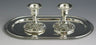 Two short silver plated candlesticks with grape cluster bases on an oval silver tray