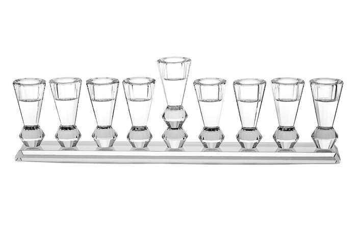 Clear crystal menorah with a row of tall faceted cups on a flat base and a raised center shamash