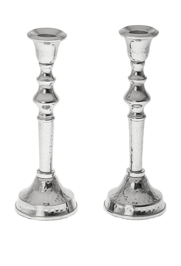 Two hammered stainless steel candlesticks with polished turned stems and domed bases