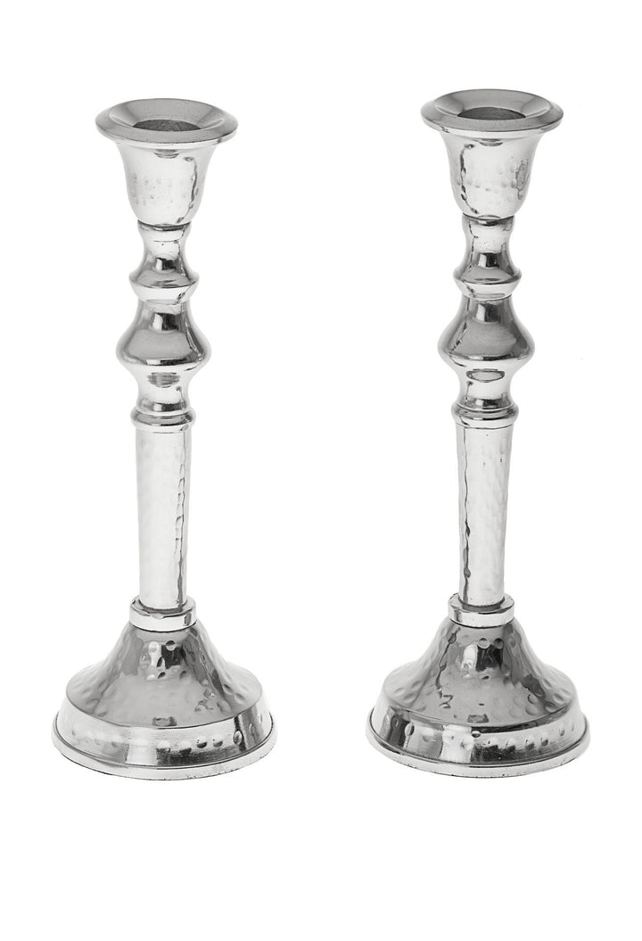 Two hammered stainless steel candlesticks with polished turned stems and domed bases