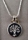 Petite round medallion with a raised silver Tree of Life on a black field, snake chain, gray backdrop
