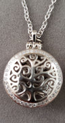Round Tree of Life locket with swirling branches and a CZ-set rim on a link chain