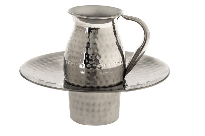 Small hammered stainless steel pitcher seated in a wide-rimmed hammered basin