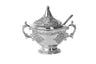 Silver plated honey dish with domed lid, spoon, scroll handles and floral panels