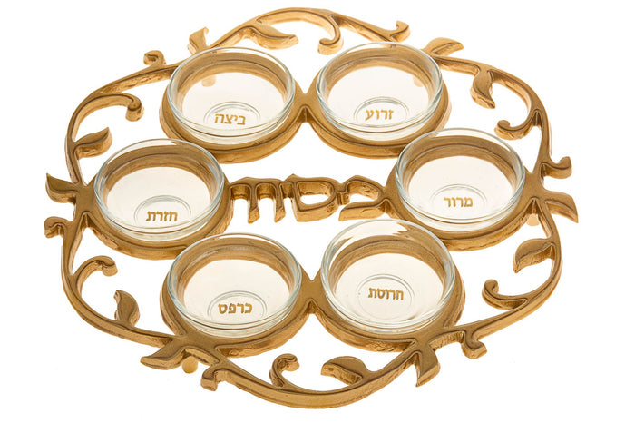 Gold-tone vine-scroll Seder plate with six glass bowls labeled in Hebrew and Pesach across the center