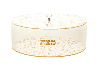 Round clear Lucite matzah holder with gold flake pattern, gold Hebrew Matzah lettering and a knobbed lid