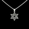 Sterling silver Star of David with scrolling filigree and small star cutout, on black