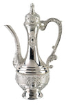 Silver-tone oil pitcher with long curved spout, scrolled handle, domed lid and embossed medallions
