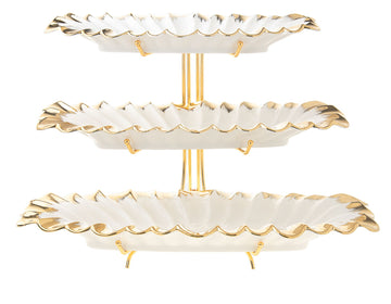 Three tiers of white porcelain serving trays edged in gold and stacked one above another