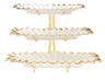 Three tiers of white porcelain serving trays edged in gold and stacked one above another