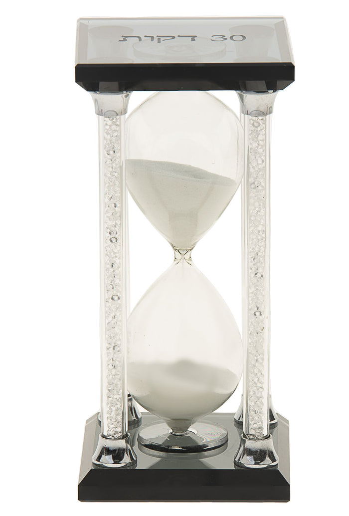 Hourglass timer with white sand, crystal-filled pillars and Hebrew 30 minutes on the dark top