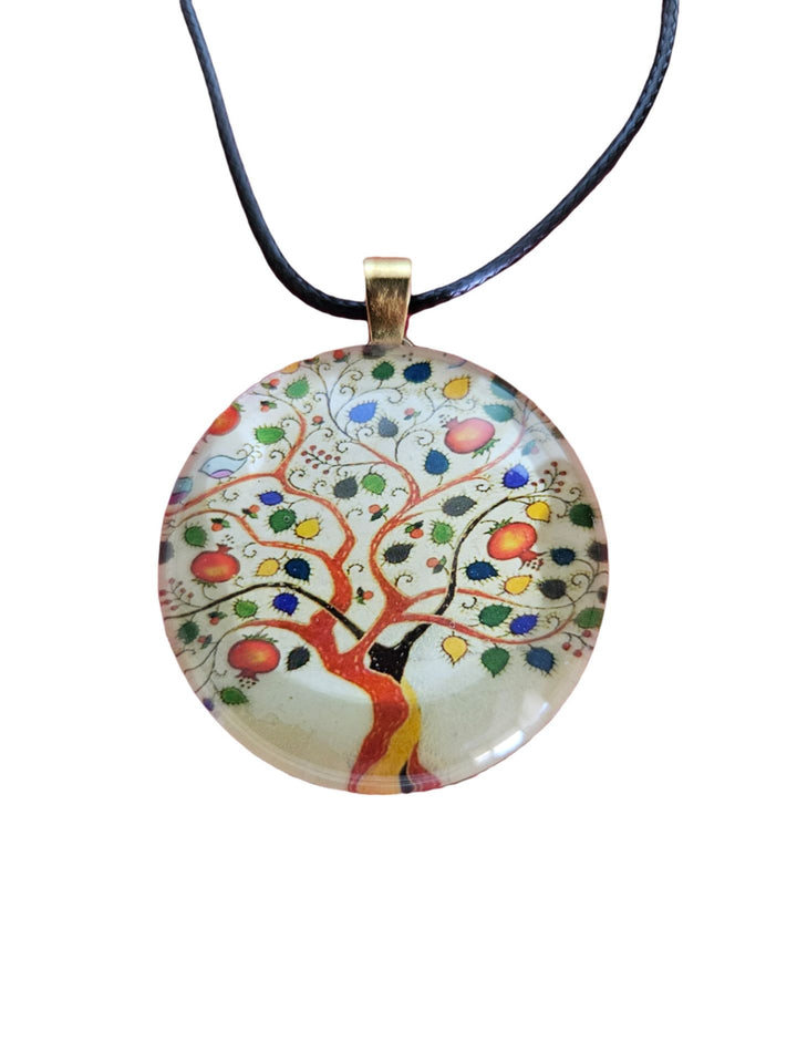 Round glass Abundance Tree of Life pendant with red fruit and colorful leaves on cream, black cord