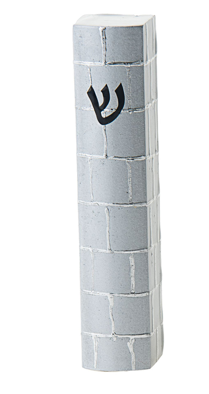 Silver toned mezuzah case with a raised brick pattern running down its narrow face