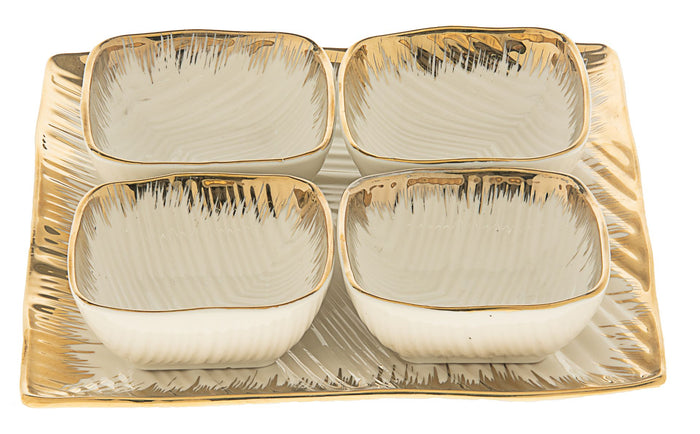 Four white porcelain square dishes with brushed gold rims on a square gold-edged tray