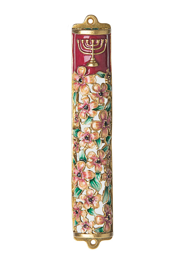 Pink enamel mezuzah case with flowers and a menorah worked into the front