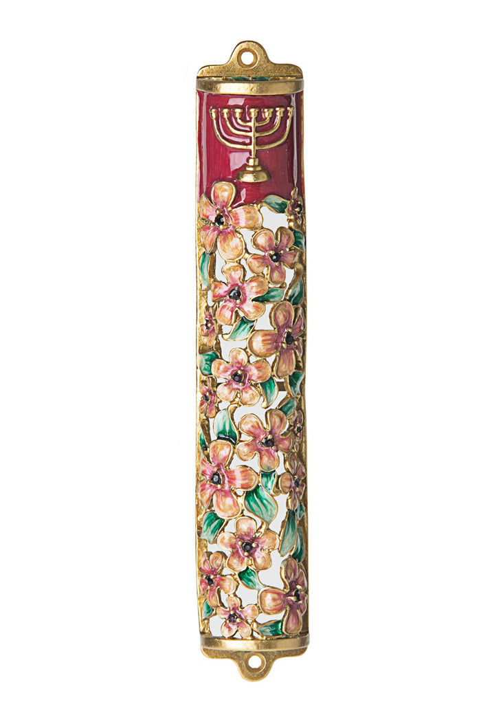 Pink enamel mezuzah case with flowers and a menorah worked into the front