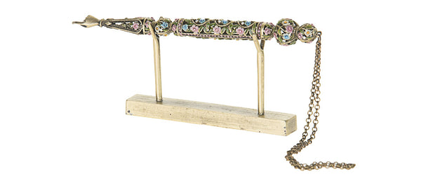 Jewelled Torah pointer with multicoloured flowers on the shaft, resting on its stand