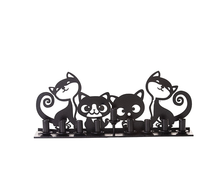 Black metal menorah with four cartoon cat silhouettes standing behind a row of candle cups