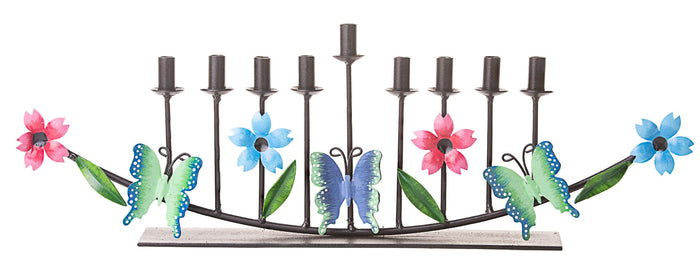 Long metal menorah formed from flowers and butterflies with candle cups along the top