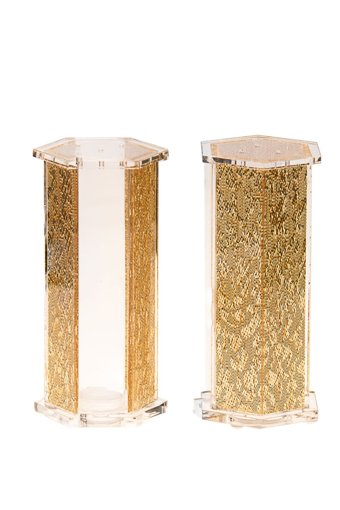 Two hexagon Lucite shakers with gold textured panels, one with a clear stripe