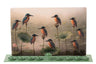 Metal Chanukah menorah sculpted as birds above a lotus pond with candle holders in the scene