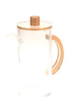 Clear lucite oil pitcher with a narrow pouring spout and a curved side handle