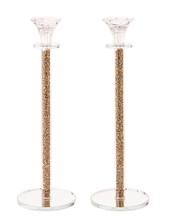 Tall crystal candlestick whose hollow stem is packed with crushed gold stones