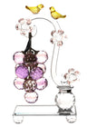 Clear crystal figurine of birds gathered among flowers, catching the light