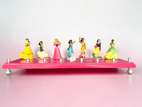 Classic Disney princess menorah — row of repurposed princess figures on pink glitter plaque | Judaica Square Lakewood