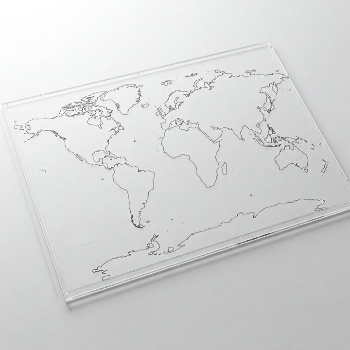 Clear lucite sheet printed with black outline world map of the continents, angled view on white