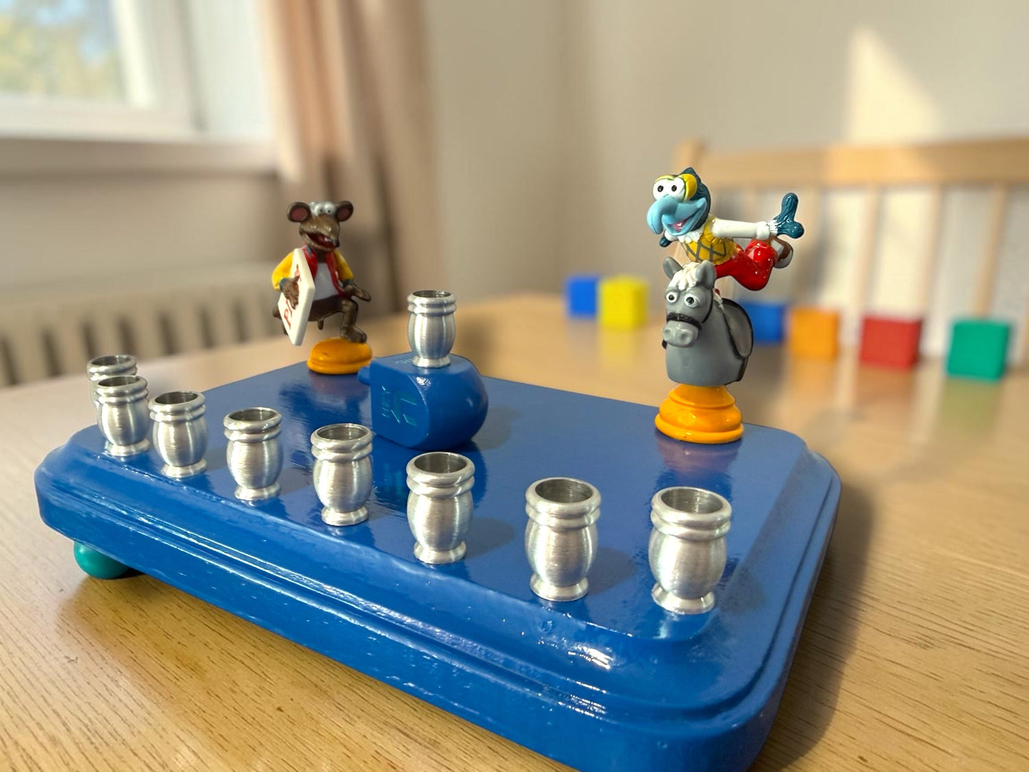 Gonzo and Ralph menorah — two Muppets chess figures sharing a painted wood plaque | Judaica Square Lakewood (view 3)